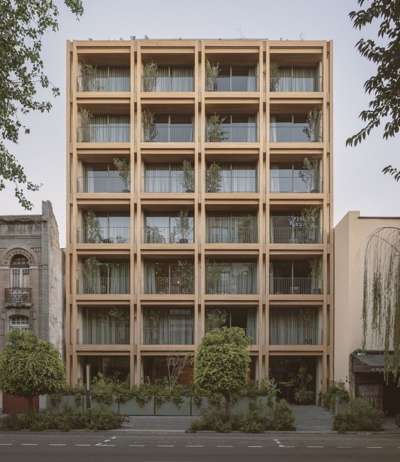 Fachada de madera de Álvaro Obregón 43, con vegetación en todos los balcones